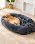 Lit ovale XL en peluche pour chien dans un salon lumineux