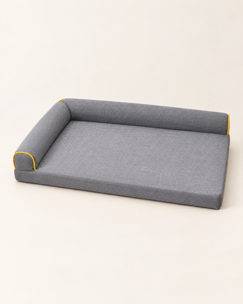 Flat dog bed with raised bolster and yellow piping, grey